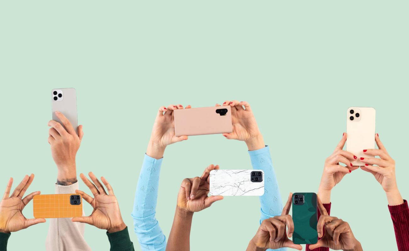 Hands holding different phones up in the air
