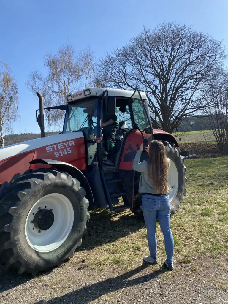 Frau film eine Person die gerade in einen Traktor einsteigt